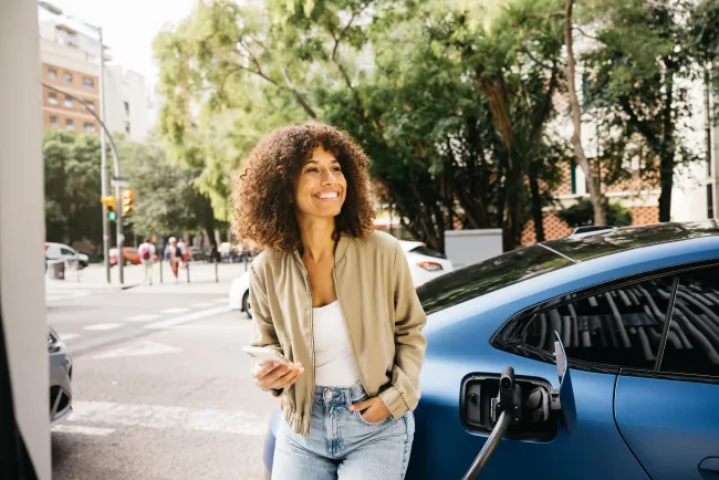 Femme qui charge sa voiture électrique