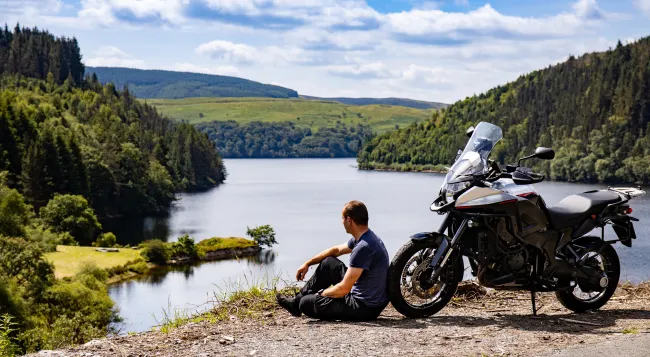 Homme qui regarde l'horizon devant sa moto