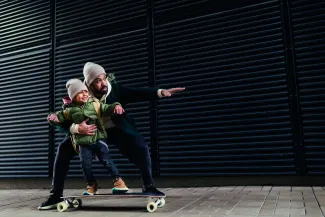Père et son fils qui font du skate dans la rue